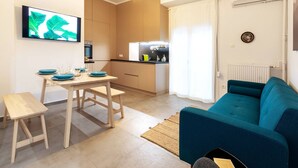 A compact living space with a dining area, kitchenette, and a sofa.