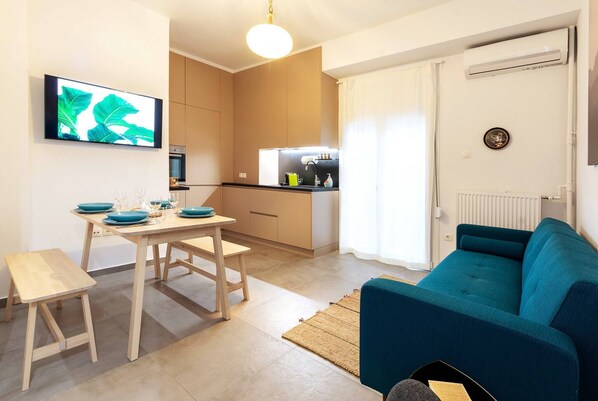 Un espacio habitable compacto con comedor, kitchenette y sofá.