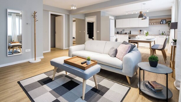 Un salon moderne comprenant un canapé, une table basse et un coin repas avec une table et des chaises.