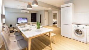 Une cuisine moderne avec un coin repas, un lave-linge et un téléviseur.