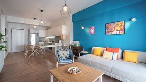 A modern living space with a dining area, kitchen, and a sofa with colorful cushions. - Exclusive Apt In The  Of Athens'_2BD+2 Bathrooms (Athens)