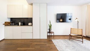 A modern kitchen with white cabinets, a black countertop, and a small potted plant. - Athens' Best Location~ Unique Magnificent Studio (Athens)