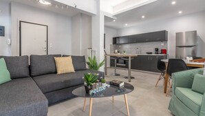 Una sala de estar moderna con un sofá, una mesa de centro y un comedor con mesa y sillas.