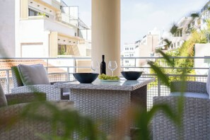 A balcony with wicker furniture, a bottle, and two glasses. - Prime central location Athens, Big Balcony (Athens)
