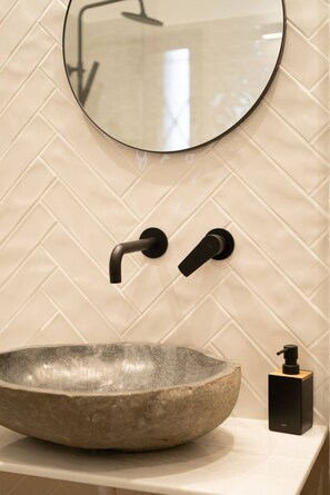 A bathroom with a stone basin, a round mirror, and a black soap dispenser. - Prime central location Athens, Big Balcony (Athens)