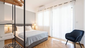 A bedroom with a bed, a chair, a wardrobe, and a window with curtains. - Prime central location Athens, Big Balcony (Athens)