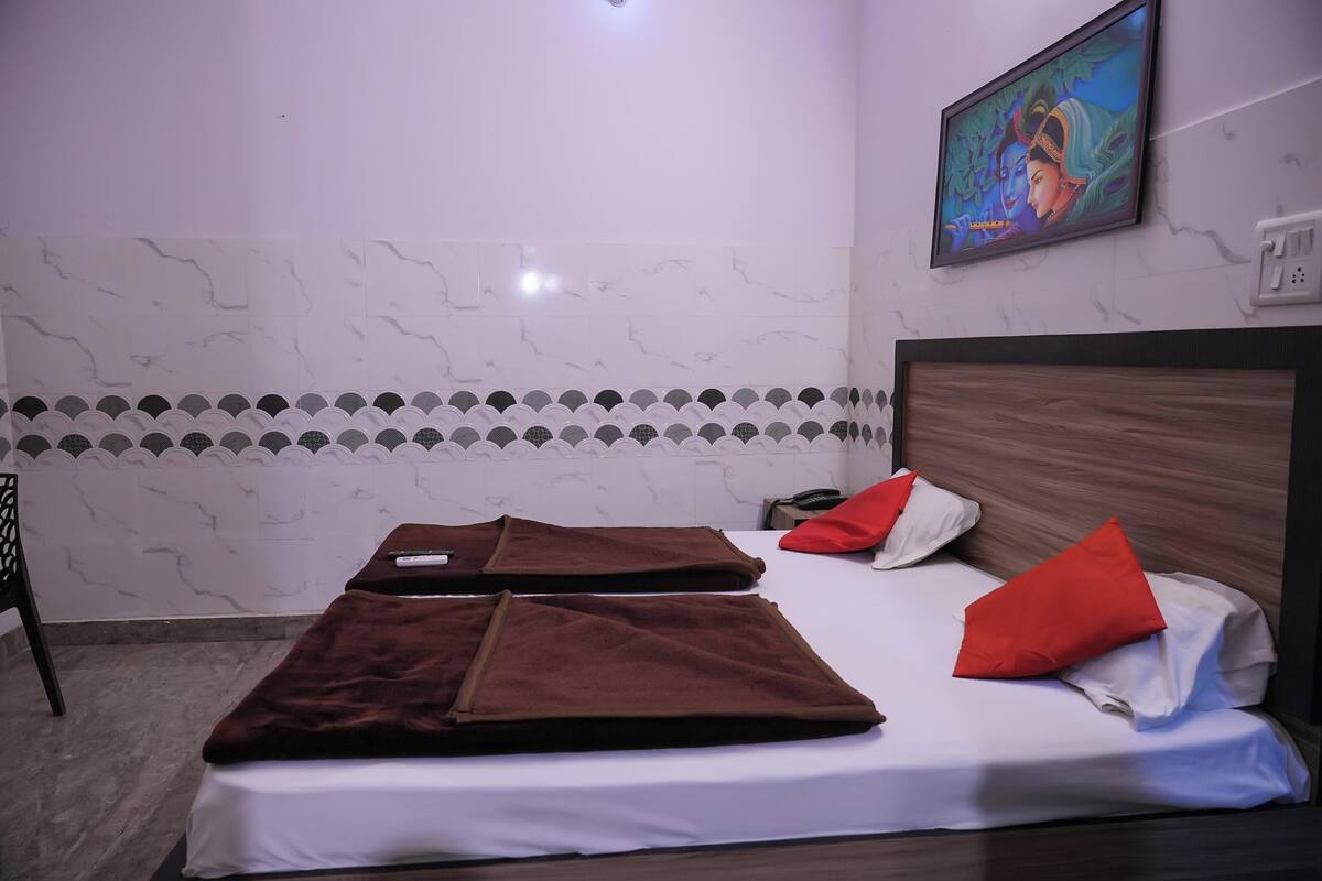 A hotel room with two beds, a wooden headboard, a painting on the wall, and a patterned tile border.