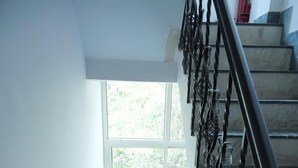 Un escalier avec une rampe en métal et une fenêtre en haut.
