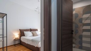 A bedroom with a bed, bedside table, and a wall-mounted light fixture. - Prime 3BR Exarcheia Penthouse | Huge Terrace (Athens)