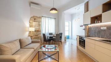 A modern living room with a sofa, coffee table, and dining area.