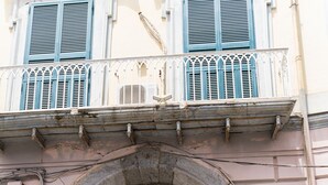 A building with a large, ornate blue door, a balcony with white railings, and a stone archway above the door. - Olivia's Home By DomusExtra (Naples)