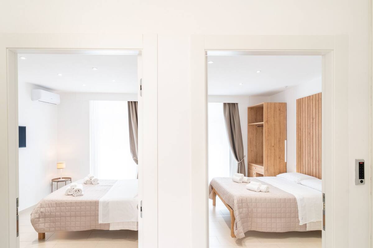 Una moderna camera d'albergo con un letto, un comodino, una lampada e un armadio in legno.