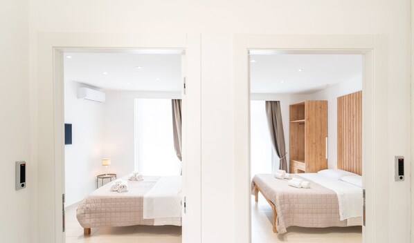 Een moderne hotelkamer met een bed, een nachtkastje, een lamp en een houten garderobe.