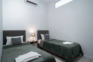 2 dormitorios y tabla de planchar con plancha