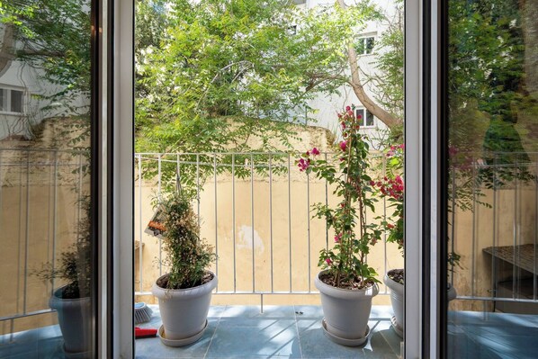 A balcony with potted plants and a metal fence. - 1BR Stylish Apt 20 Minutes from Acropolis (Athens)