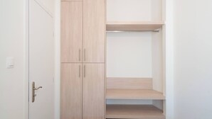 A walk-in closet with wooden doors and shelves.