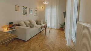Una sala de estar con sofá, una mesita, una lámpara y un radiador.