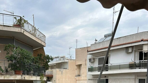 Un balcón con una mesa, una silla y una computadora portátil.