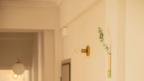 Un pasillo con suelo de madera, un radiador y una puerta.