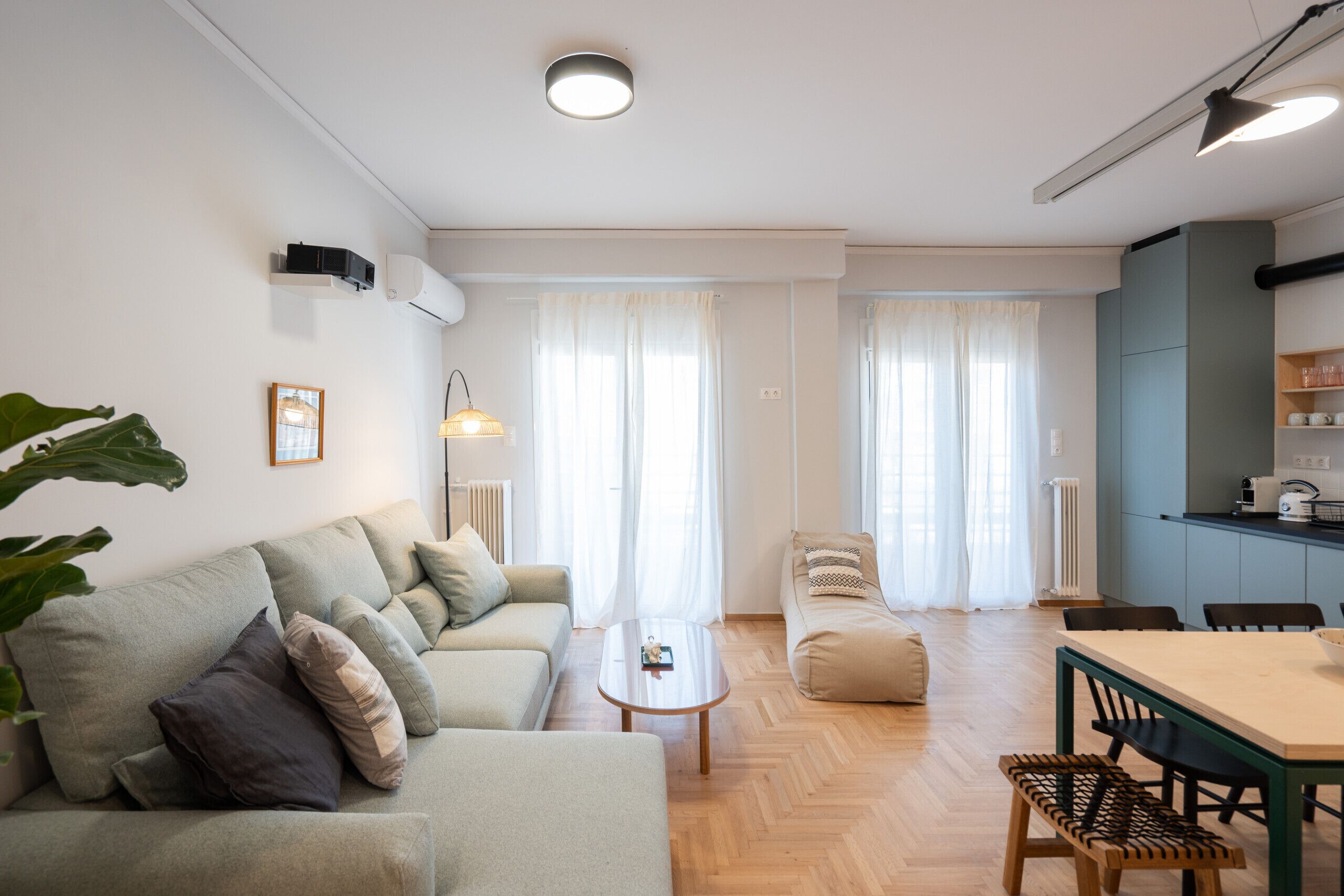 A modern living room with a sofa, coffee table, and dining area.