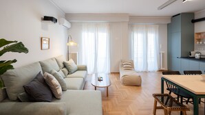 A modern living room with a sofa, coffee table, and dining area.