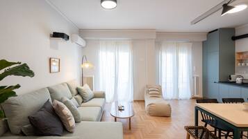 A modern living room with a sofa, coffee table, and dining area.