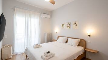 A bedroom with a bed, a ceiling fan, a window with curtains, wall-mounted lights, and a radiator.