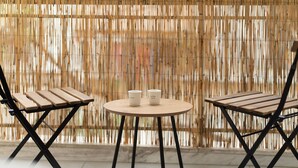 Una mesa redonda con dos sillas y dos tazas de café.