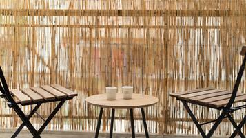 A round table with two chairs and two coffee cups.