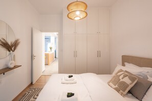 A bedroom with a bed, bedside tables, a wardrobe, and a hanging light fixture. - My Happy Greek Home (Athens)
