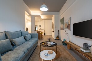 A modern living room with a sofa, coffee table, and artwork on the walls. - My Happy Greek Home (Athens)