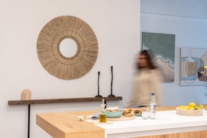A modern kitchen with a wooden countertop, a decorative wall piece, and a painting. - My Happy Greek Home (Athens)