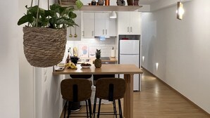 Une cuisine moderne avec des armoires blanches, un plan de travail en bois et une plante suspendue.