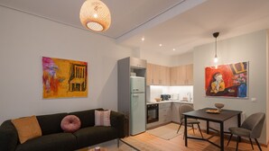 A modern apartment with a living room, kitchenette, dining area, and a glass coffee table.