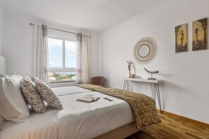 Relax in a stylish room with a large bed, side table, and city views.
