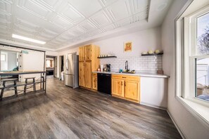 Een moderne keuken met houten kastjes, een roestvrijstalen koelkast en een vaatwasser.