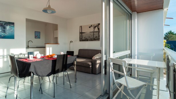 Ein modernes Wohnzimmer mit Essbereich, einer Couch und einem Balkon mit Blick.