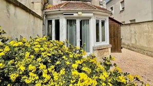 Un bâtiment doté d’une baie vitrée et d’un petit espace porche.
