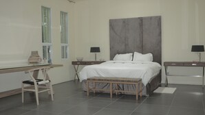 Ein modernes Schlafzimmer mit einem großen Bett, einem Schreibtisch und zwei Nachttischen.