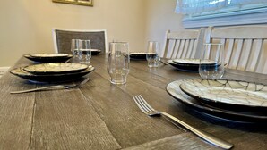 A dining table set with plates, glasses, and cutlery.
