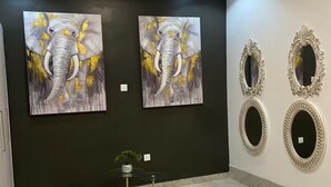 A hallway with two elephant paintings on the wall, a small plant, and two ornate mirrors. - B&B Charming bed & breakfast in gorgeous Accra with WiFi, AC (Accra)