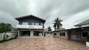 A building with a sign reading "MAQUEEN ROYAL IMPRESDS" and a pet shop sign. - B&B Charming bed & breakfast in gorgeous Accra with WiFi, AC (Accra)