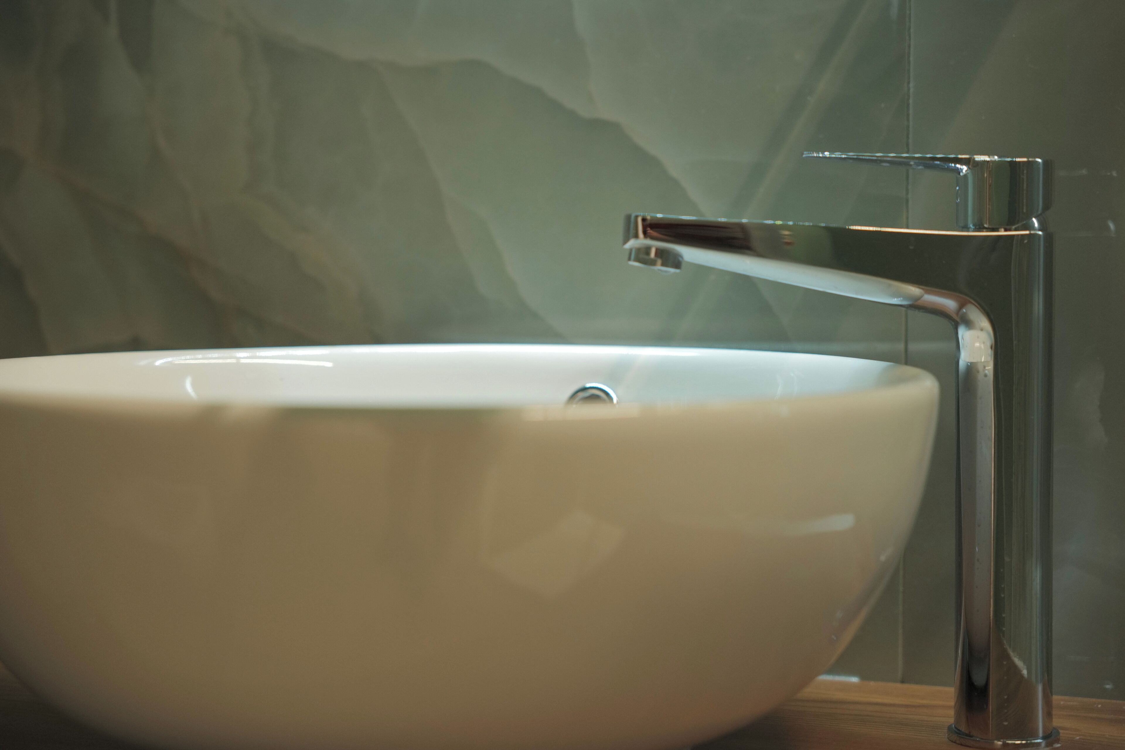 A white ceramic sink with a chrome faucet in a bathroom.