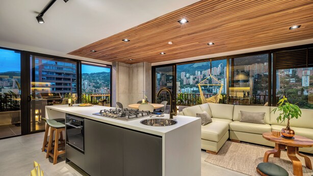 Een moderne keuken met een centraal eiland, een eethoek met een ronde tafel, en een bank.