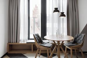 Un comedor moderno con una mesa redonda de madera, dos sillas acolchadas y un banco.