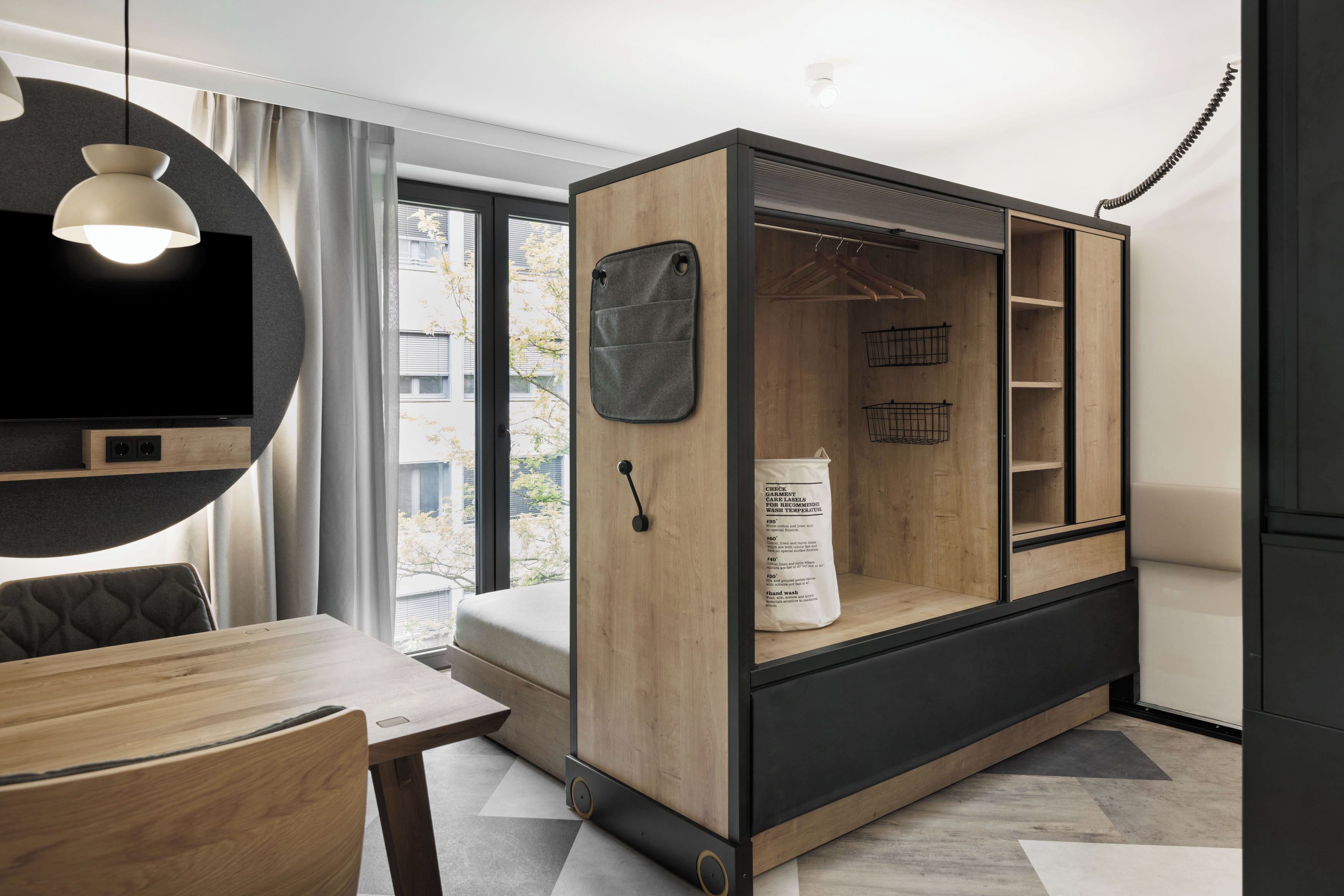 A modern room with a wooden cabinet, a TV, a dining table, and a large window.