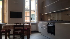 Una cocina moderna con comedor, que cuenta con un ventanal grande, armarios empotrados y una estufa a gas.