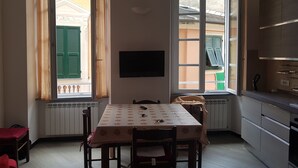 Un comedor con una mesa, sillas, un radiador y un televisor en la pared.