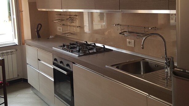 Una cocina moderna con electrodomésticos de acero inoxidable, horno empotrado y una isla grande con fregadero.