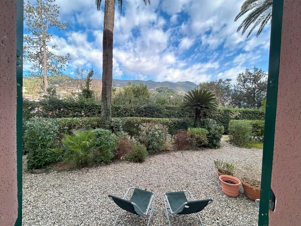 A patio with two chairs, a gravel ground, and a view of a mountainous landscape. - Villa Marina beautiful house by the sea - Parking (Monterosso al Mare)